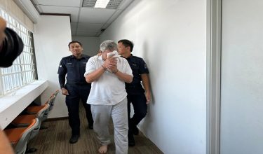 Suspek diiringi polis ketika tiba di mahkamah untuk permohonan reman
