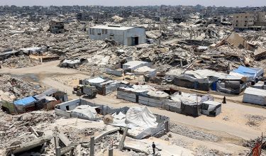 Tents and shelters are pictured next to rubble of collapsed buildings at a camp for people displaced by war in the Sheikh Radwan neighbourhood of Gaza City on July 6, 2026. The Palestinian Islamist movement Hamas announced on July 6 the dissolution of the body that has governed the Gaza Strip for nearly two decades, clearing the way for a technocratic committee to implement civilian rule. Since a ceasefire took effect in Gaza last October between Hamas and Israel, the group has repeatedly said it is prepared to step aside from day-to-day governance, but the thorny issue of its disarmament remains unresolved. (Photo by Omar AL-QATTAA / AFP)