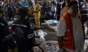 Members of emergency personnel work next to covered bodies at the site of a deadly fire at a pub in Bangkok, Thailand, July 13, 2026. REUTERS/Chalinee Thirasupa