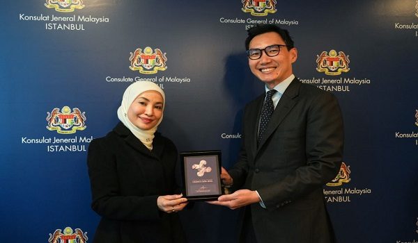 Datuk Adzliana menyampaikan plak penghargaan kepada Pesuruhjaya Perdagangan Perbadanan Pembangunan Perdagangan Luar Malaysia (MATRADE) di Istanbul, Sadat Foster Maad.