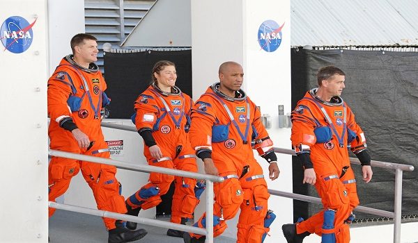 Artemis II lunar mission astronauts pause outside the Neil A. Armstrong Operations and Checkout Building during their Countdown Demonstration Test at the Kennedy Space Center in Cape Canaveral, Florida on December 20, 2025. (L-R) Canadian Space Agency astronaut and NASA Artemis II Mission Specialist Jeremy Hansen, NASA astronaut and Artemis II Mission Specialist Christina Koch, NASA astronaut and Artemis II pilot Victor Glover and NASA astronaut and Artemis II Commander Reid Wiseman. Designed to test launch-day procedures, the test is a dress rehearsal of what will happen on launch day, which is currently targeted for no earlier than February 1, 2026. (Photo by Gregg Newton / AFP)