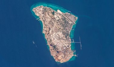 This handout image taken by the European Space Agency (ESA) captured by the Copernicus Sentinel-2 satellite shows a view of Iran's Kharg Island, which hosts the countrys main crude export terminal and is responsible for the overwhelming majority of its oil shipments to the world, about 30 kilometres south of the mainland in the north of the Gulf, on March 7, 2026. The US and Israel have previously treaded carefully around the island in the conflict, but an Axios report over the weekend cited Trump administration officials saying capturing Kharg was on the table. The island handles roughly 90 percent of Iran's crude exports, according to a JP Morgan note released on March 8. (Photo by EUROPEAN SPACE AGENCY / AFP) / RESTRICTED TO EDITORIAL USE - MANDATORY CREDIT "AFP PHOTO / ESA" - HANDOUT - NO MARKETING NO ADVERTISING CAMPAIGNS - DISTRIBUTED AS A SERVICE TO CLIENTS