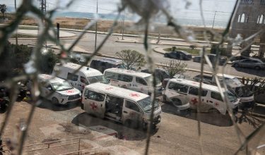 Damaged Lebanese Red Cross vehicles, seen through a broken glass window, after a drone strike damaged vehicles and a building, slightly injuring three workers, in Tyre, Lebanon, April 13, 2026. REUTERS/Louisa Gouliamaki     TPX IMAGES OF THE DAY