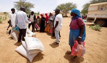 FILE PHOTO: Halime Adam Moussa, a Sudanese refugee who is seeking refuge in Chad for a second time, waits with others to share food portions, received from World Food Programme (WFP), near the border between Sudan and Chad in Koufroun, Chad, May 9, 2023. REUTERS/Zohra Bensemra/File Photo