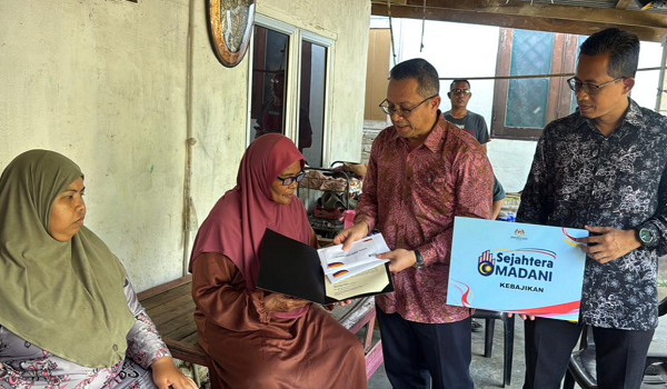 Datuk Abdul Kahar (dua kanan) menyerahkan sumbangan kepada nenek mangsa, Esah Salleh
