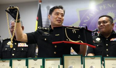 Tan Sri Azam Baki menunjukkan barang sitaan pada sidang media bulanan SPRM. /Foto SPRM