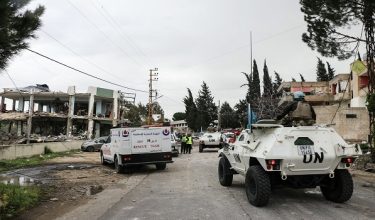 United Nations peacekeepers with the UN Interim Force in Lebanon (UNIFIL) drive past a destroyed healthcare centre building in the aftermath of an Israeli strike in the southern Lebanese town of Burj Qalawiya on March 14, 2026. An overnight Israeli strike killed a dozen medical staff at a clinic in south Lebanon, health authorities said earlier on March 14, after the Iran-backed Hezbollah's leader said his group was ready for a long confrontation with Israel. Lebanon was drawn into the Middle East war last week when the militant group attacked Israel in response to the killing of the Iranian supreme leader in US-Israeli strikes. (Photo by Kawnat HAJU / AFP)