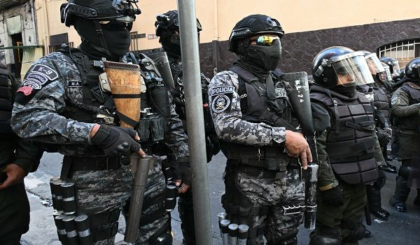 Riot police stand guard as education workers protest against the government of Bolivian President Rodrigo Paz outside the Labour Ministry, in La Paz, on May 13, 2026. For the past two weeks, workers, farmers, school teachers, Indigenous groups and transport workers have been pressuring the government. Their demands range from wage increases and economic stabilization to opposition to the privatization of public companies. (Photo by AIZAR RALDES / AFP)