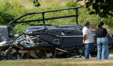 People stand near parts of a helicopter lying on the ground following a deadly collision between two helicopters in Rio de Janeiro, Brazil, June 14, 2026. REUTERS/Ricardo Moraes