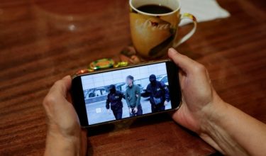 Seorang individu menonton paparan berita di telefon pintar mengenai rakaman operasi perkhidmatan keselamatan Rusia (FSB) menahan seorang wartawan Jepun yang dituduh terlibat dalam kegiatan pengintipan, di Moscow / Foto AFP