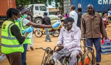 Pegawai Kementerian Kesihatan Kenya memeriksa suhu badan seorang pengembara di Pusat Pemeriksaan Sempadan Sehenti Busia (OSBP), di sempadan Kenya-Uganda, ketika pihak berkuasa kesihatan memperketat saringan Ebola di Busia.