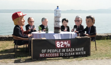 Sebagai simbolik demonstrasi, aktivis memaparkan sebotol air kotor berlabel "Gaza" di tengah-tengah meja yang dikelilingi replika pemimpin G7 yang sedang menikmati air bersih.