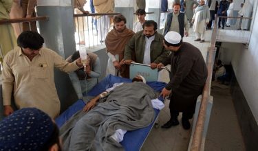 This photograph taken on February 16, 2026 shows relatives carrying an injured blast victim inside a hospital in Bannu city of Pakistans Khyber Pakhtunkhwa province. Two bomb attacks and a gunfight between police and militants in northwest Pakistan killed at least 11 security personnel and 3 civilians, including a child, a security official said late February 16. (Photo by Karim ULLAH / AFP)
