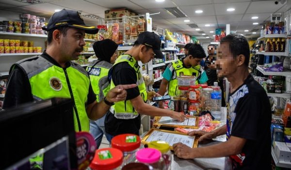 Anggota KPDN dan JIM menjalankan pemeriksaan dalam operasi bersepadu Op Kita Gempur di sekitar Brickfields, malam tadi/Foto BERNAMA