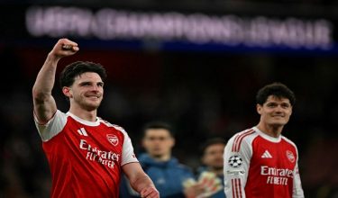 Arsenal's English midfielder #41 Declan Rice (L) celebrates at the final whistle during the UEFA Champions League, last 16 second leg football match between Arsenal and Bayer Leverkusen at the Emirates Stadium in north London on March 17, 2026. Arsenal won the match 2-1. (Photo by Glyn KIRK / AFP)