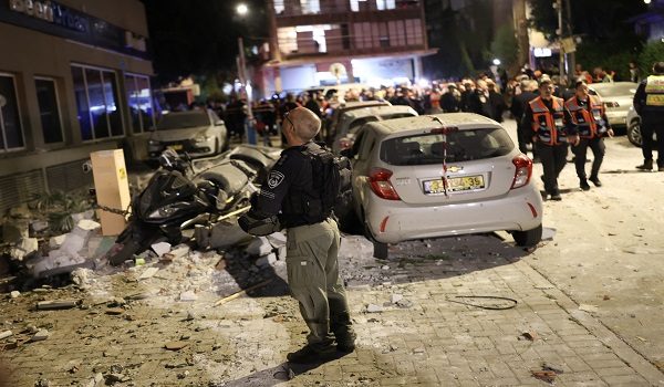 Police and first responders work at a scene where an apartment was damaged by a missile strike, in the outskirts of Tel Aviv, Israel on March 18, 2026. (Photo by Ilia YEFIMOVICH / AFP) /