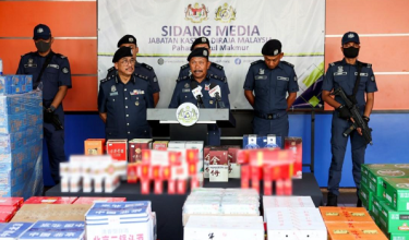 Pengarah JKDM Pahang, Mohd Asri menunjukkan rokok dan minuman keras pelbagai jenis dan jenama yang dirampas dalam tiga serbuan berasingan di Kawasan Perindustrian Teluk Kalung, Kemaman, Terengganu, 3 Julai lalu./ BERNAMA