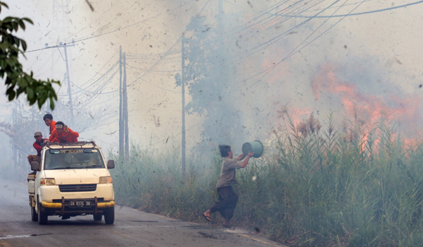 Penduduk di Kampung Sungai Tabuk, Kabupaten Banjar cuba memadam kebakaran/ AFP