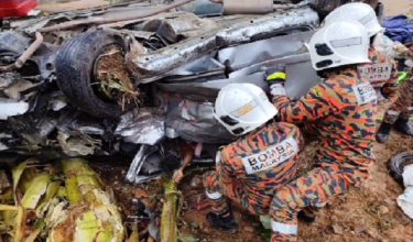 Anggota bomba mengeluarkan mayat dua beranak yang tersepit di dalam kenderaan.