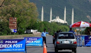 Pegawai polis mengawal kenderaan di sekatan jalan raya di Islamabad menjelang rundingan damai AS-Iran/Foto REUTERS