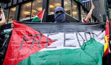 Seorang penunjuk perasaan mengibarkan bendera sempena perarakan Hari Tahanan Palestin di New York City/Foto REUTERS