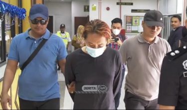 Tertuduh diiringi polis ketika tiba di mahkamah
