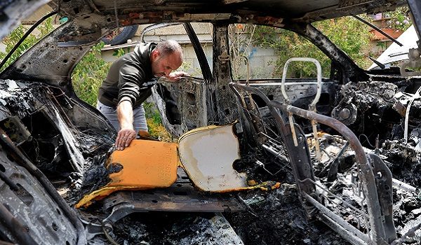 A man checks a damaged car, which Palestinians say was burned by Israeli settlers, in Surif near Hebron in the Israeli-occupied West Bank May 17,2026. REUTERS/Yosri Aljamal     TPX IMAGES OF THE DAY