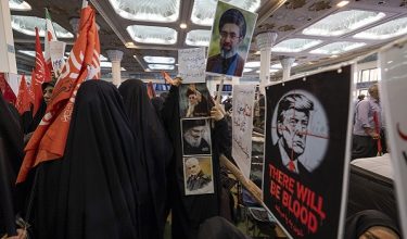 Veiled pro-government supporters walk past portraits of Iran's Supreme Leader Ayatollah Mojtaba Khamenei and U.S. President Donald Trump during a ceremony commemorating the late Supreme Leader Ayatollah Ali Khamenei at the Imam Khomeini Grand Mosque in downtown Tehran, Iran, on August 18, 2026. Ayatollah Khamenei was killed on the first day of U.S. military operations in Tehran. (Photo by Morteza Nikoubazl/NurPhoto)NO USE FRANCE