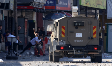 Penduduk Palestin membaling batu ke arah kenderaan tentera Israel semasa serbuan di Kem Pelarian Al-Amari berhampiran Ramallah, Tebing Barat. Foto- AFP