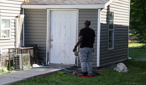 SENSITIVE MATERIAL. THIS IMAGE MAY OFFEND OR DISTURB A man uses a water hose to wash blood from a door after children, with ages ranging from 1 to 14, were killed in a mass shooting incident described as domestic violence, in Shreveport, Louisiana, U.S. April 19, 2026.  REUTERS/Kevin Bartram     TPX IMAGES OF THE DAY
