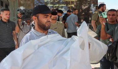 Seorang lelaki membawa jenazah ahli keluarganya yang terkorban dalam serangan udara Israel di sebuah pangsapuri di kawasan al-Sabra di sini. / Foto AFP