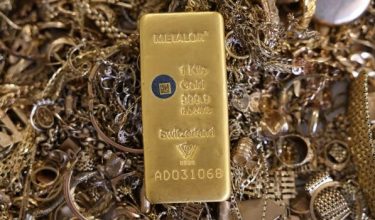 Sebongkah emas diletakkan di atas timbunan barangan emas yang akan dileburkan di Hatton Garden Metals, London, Britain