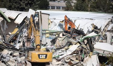 A photograph shows heavy machinery demolishing a structure inside the headquarters of the United Nations Relief and Works Agency (UNRWA) in the Sheikh Jarrah neighbourhood of Israeli-annexed east Jerusalem on January 20, 2026. The chief of the UN's agency for Palestinian refugees denounced the Israeli authorities' seizure of assets from its east Jerusalem compound earlier this month, which police told AFP was part of a debt-collection operation. The compound in Israeli-annexed east Jerusalem has been empty of UNRWA staff since January, when the law banning its operations took effect after a months-long battle over its work in the Gaza Strip. Israel had accused UNRWA of providing cover for Hamas militants, and the legislation also forbids contact between the agency and Israeli officials. (Photo by ilia yefimovich / AFP)