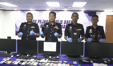 Ketua Polis Daerah Melaka Tengah, ACP Christopher Patit (dua, kanan) menunjukkan barangan yang dirampas pada sindiket penipuan khidmat seks dalam talian/ RTM