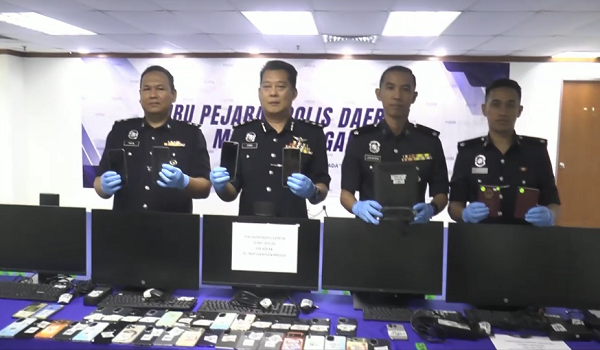 Ketua Polis Daerah Melaka Tengah, ACP Christopher Patit (dua, kanan) menunjukkan barangan yang dirampas pada sindiket penipuan khidmat seks dalam talian/ RTM
