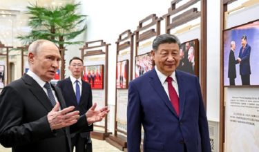 In this pool photograph distributed by the Russian state agency Sputnik, Russia's President Vladimir Putin and China's President Xi Jinping tour a photo exhibition on Russia-China ties in Beijing on May 20, 2026. (Photo by Alexander KAZAKOV / POOL / AFP)