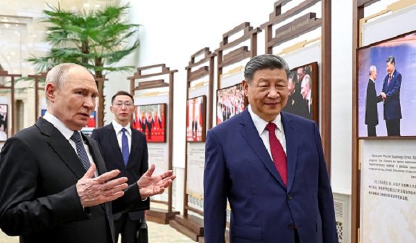 In this pool photograph distributed by the Russian state agency Sputnik, Russia's President Vladimir Putin and China's President Xi Jinping tour a photo exhibition on Russia-China ties in Beijing on May 20, 2026. (Photo by Alexander KAZAKOV / POOL / AFP)