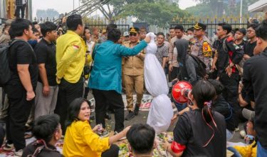 Penunjuk perasaan pelajar menyerahkan patung berkafan melambangkan mangsa jerebu kepada pegawai kerajaan di Palangkaraya, Indonesia/Foto AFP