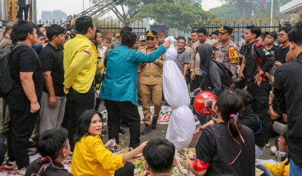 Penunjuk perasaan pelajar menyerahkan patung berkafan melambangkan mangsa jerebu kepada pegawai kerajaan di Palangkaraya, Indonesia/Foto AFP
