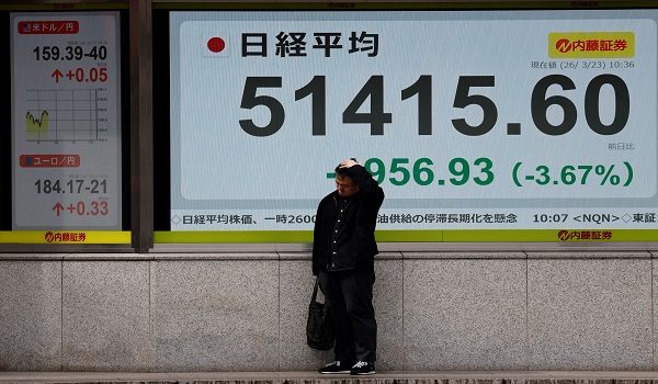 Seorang lelaki berdiri di hadapan papan paparan harga saham yang menunjukkan kadar pertukaran dolar Amerika Syarikat berbanding yen Jepun serta purata indeks Nikkei di luar sebuah firma broker di Tokyo, Jepun/ REUTERS