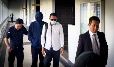 Mohd Hafiz Ahmad, 41, (belakang, tengah) di pekarangan Mahkamah Sesyen Kuala Lumpur hari ini