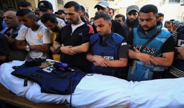 FILE PHOTO: Al Jazeera journalist Anas Al Sharif, who was killed in an Israeli strike on August 10, 2025, prays next to the body of his colleague Al Jazeera reporter Ismail al-Ghoul, who also was killed in an Israeli strike on July 31, 2024, during al-Ghoul's funeral in Gaza City July 31, 2024. REUTERS/Dawoud Abu Alkas/File Photo