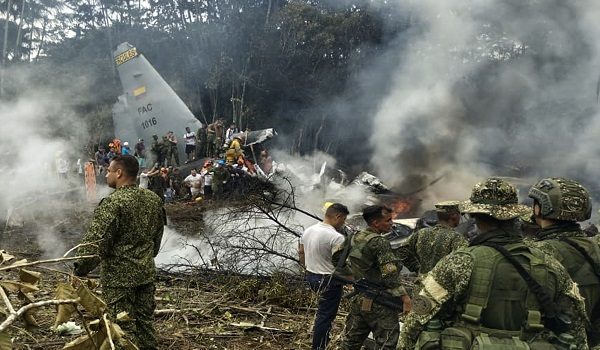 This screen grab shows soldiers and rescuers near an Air Force Hercules emitting thick smoke after the aircraft crashed during takeoff in Puerto Leguizamo, Colombia, near the southern border with Ecuador, on March 23, 2026. Colombia's military said on March 23 that about 80 troops were believed to be dead after a transport plane crash in the south of the country. (Photo by daniel ortiz / AFP)