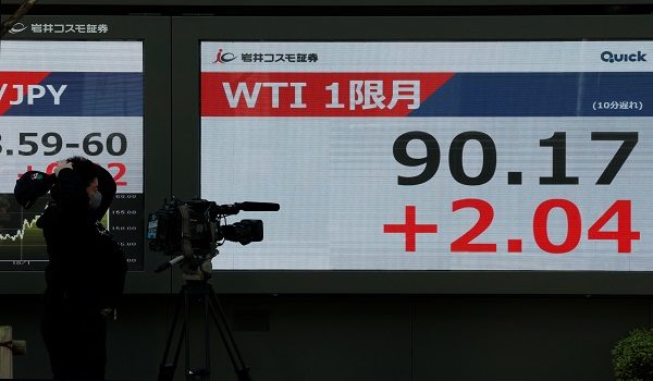 Seorang jurukamera televisyen merakam papan paparan harga saham yang menunjukkan niaga hadapan minyak mentah WTI 1 di Tokyo, Jepun/ REUTERS