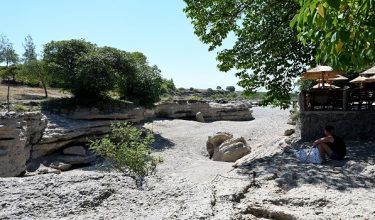 This photograph shows the dried-up riverbed of the Cijevna River as prolonged hot and dry weather continues to grip the western Balkans, leaving rivers and reservoirs at unusually low levels, near Podgorica, Montenegro, on August 20, 2026. Climate change has intensified a drought across Europe this summer, with extreme heat driving the exceptionally dry conditions, according to experts. (Photo by SAVO PRELEVIC / AFP)