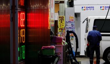 Seorang pekerja mengisi petrol ke dalam kenderaan pelanggan di sebuah stesen minyak di Tokyo, Jepun/Foto REUTERS