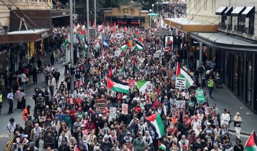 Peserta himpunan memegang sepanduk ketika mereka mengambil bahagian dalam 'Nationwide March for Palestine' di Sydney / Foto REUTERS