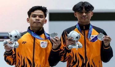 Atlet e-sukan negara Muhammad Hariz Hazmi Hakimin dan Farish Luzman menunjukkan pingat perak yang dimenangi dalam acara eFootball pada Sukan Asia Aichi-Nagoya 2026. - Foto BERNAMA