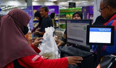 Petugas pasar raya mengimbas MyKad seorang pengunjung yang membeli barangan keperluan harian menggunakan bantuan Sumbangan Asas Rahmah (SARA)/ BERNAMA