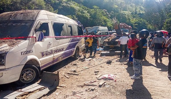 People look at vehicles destroyed by a bomb attack at El Tunel, on the Popayan-Cali road, in Cajibio, Cauca department, Colombia, on April 25, 2026. A bomb attack on April 25 left seven people dead and 20 injured in an area of Colombia with a strong guerrilla presence, amid a spate of attacks just over a month before the presidential elections, the governor of the Cauca region said. (Photo by Francisco Calderon / AFP)